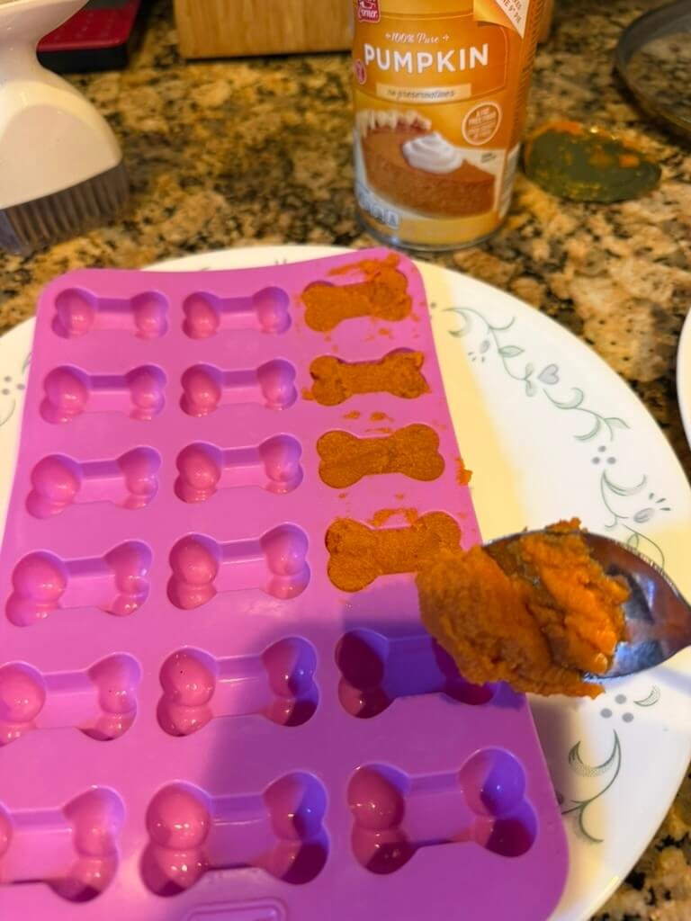 Filling dog bone molds with pumpkin